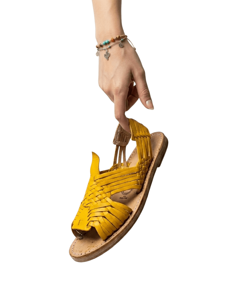 Hand holding a yellow woven huarache sandal